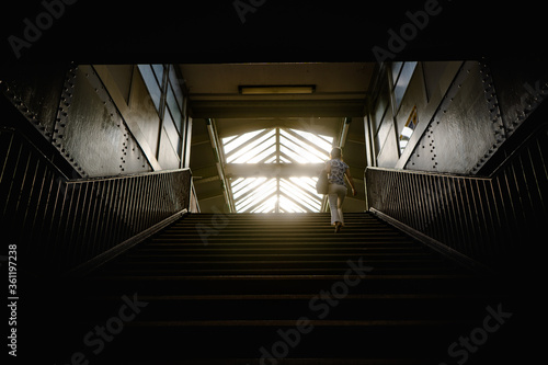 woman walking up the dark stairway
