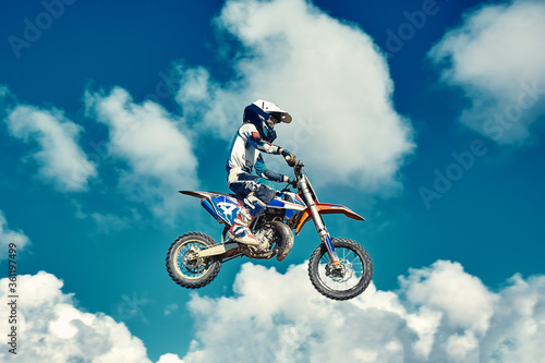 Motocross concept, a biker goes off-road making extreme skiing. In pursuit of adrinalin, sport concept. Dangerous sport.