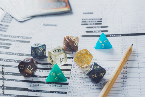 Colorful dices and pencil on a character sheet. Role playing game or rpg concept. photo