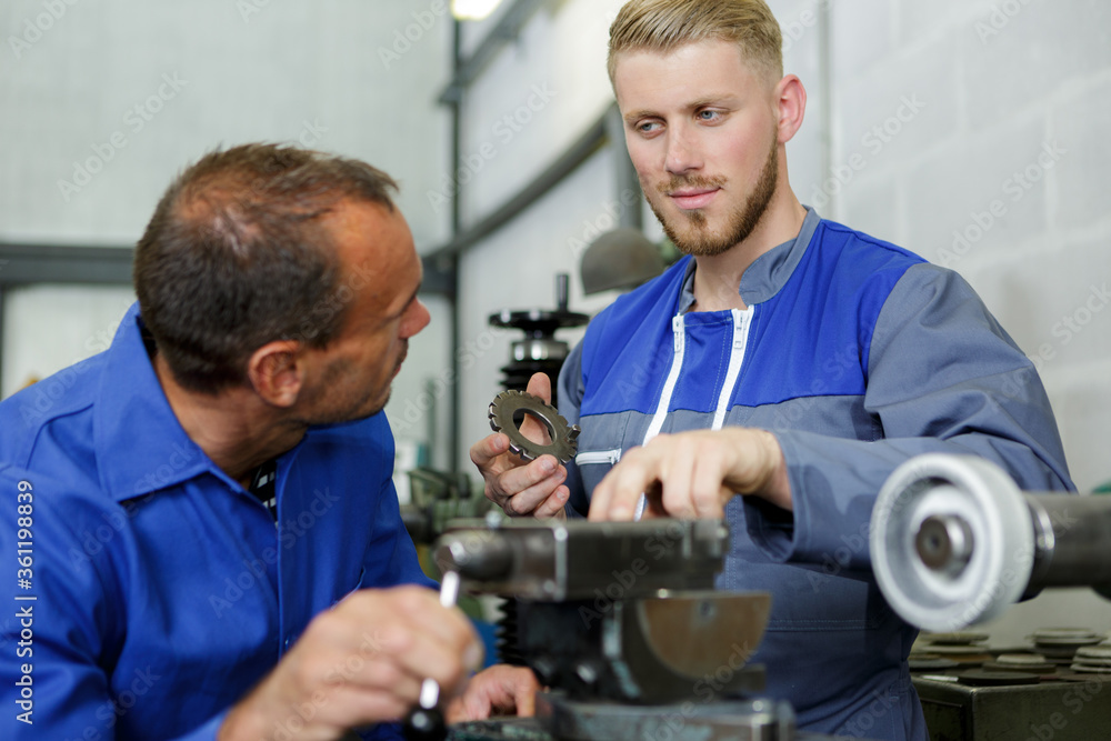 two mechanics working on a car two mechanics working on a car