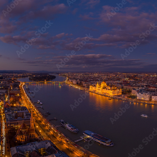 Aerial drone of lighted Hungarian Parliament by Danube river after Budapest sunset hour