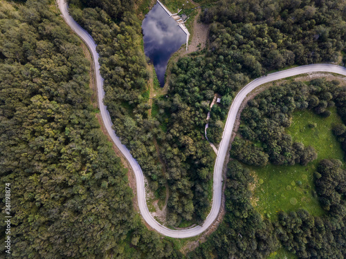Top down aerial view on road with curves between the forest in nature on mountain range - Drone photo forest and asphalt road travel concept - Stara Planina Old Mountain travel destination in Serbia