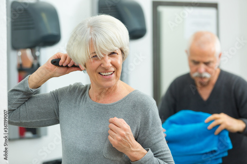 senior woman brushing her hair after fitness class