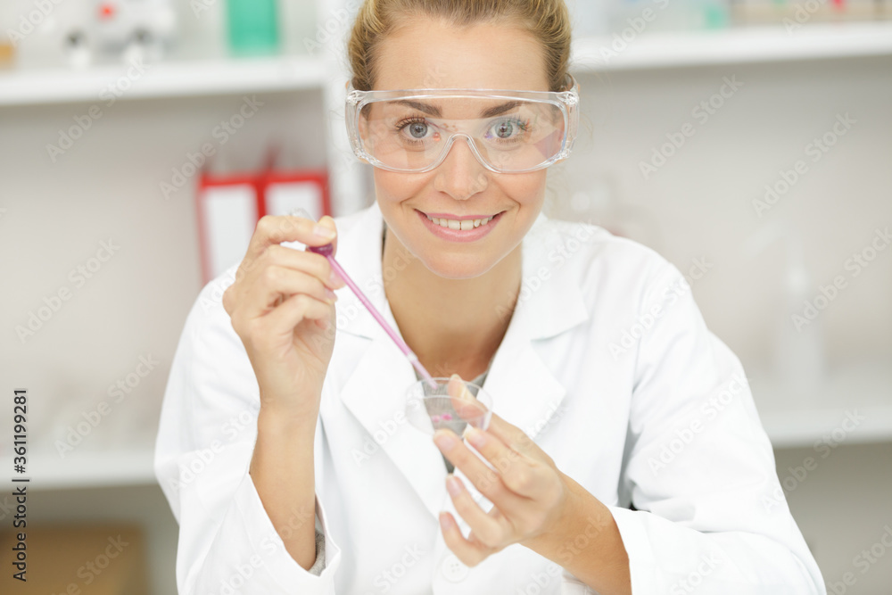 woman scientist adding liquid to test tube woman scientist adding liquid to test tube