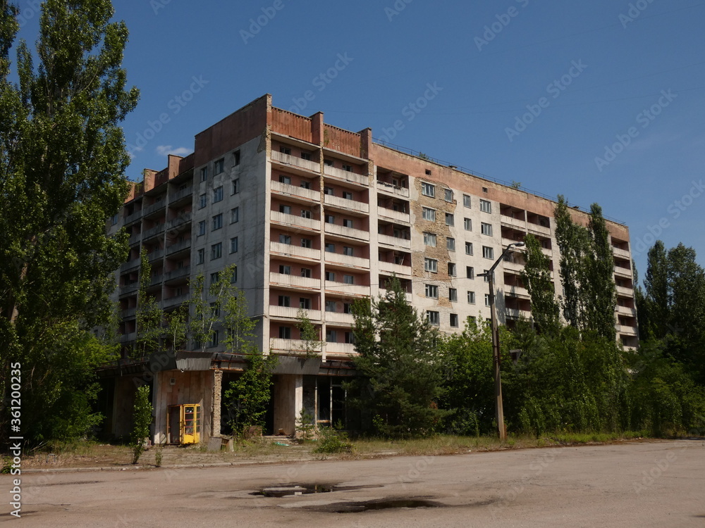 Abandoned block of flats surrounded by green trees in the ghost city of Pripyat, Chernobyl Exclusion Zone, Ukraine (June 2019)