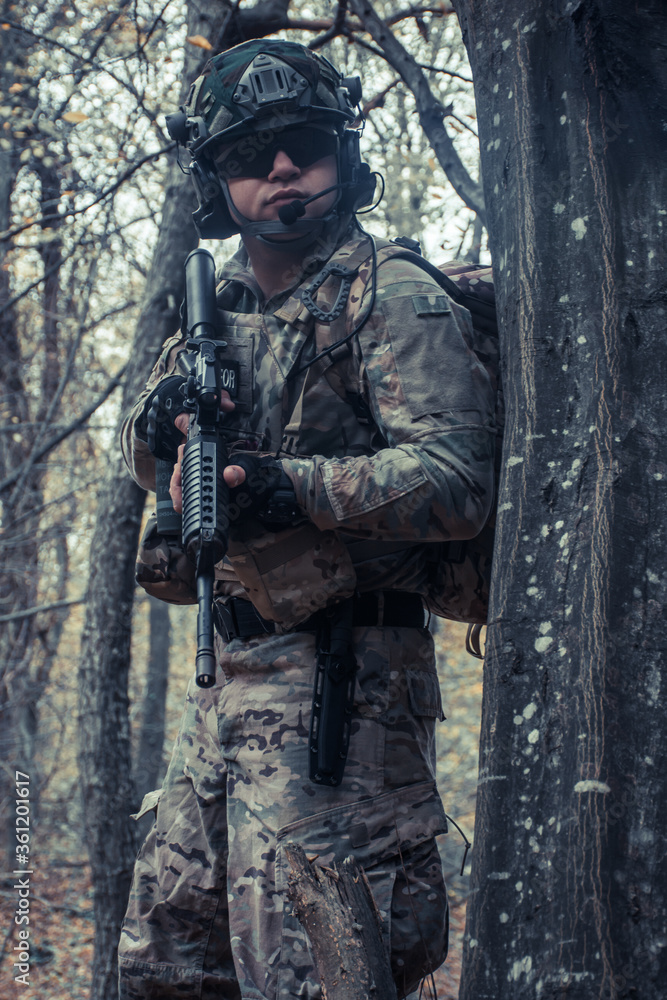 portrait of a soldier with a  gun in the forest of Battlefield/army uniform with a weapon.
