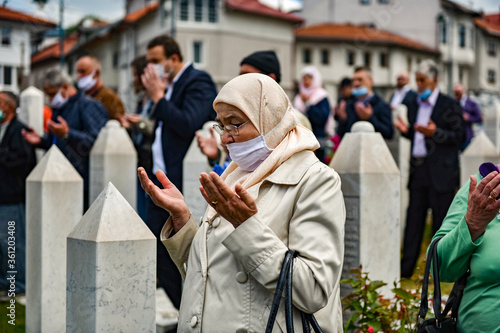 Sarajevo, Bosnia and Herzegovina, May 2020, An elderly Muslim woman with a hijab pays tribute to her sons who died in the 1995 war