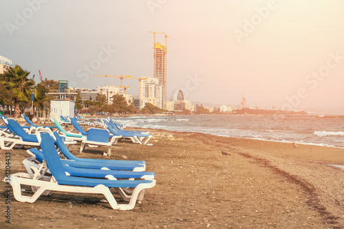 Empty Limassol sandy beach with chairs without people and tourists, Cyprus. Copy space for text.