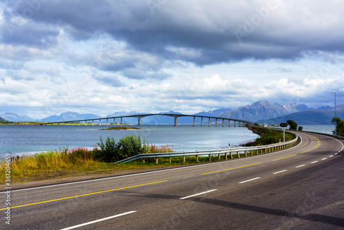 concrete bridge with harbor in background, shot under bright summer light at Stokmarknes, Hadseloya, Vesteralen, Norway photo