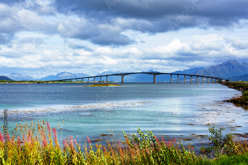 concrete bridge with harbor in background, shot under bright summer light at Stokmarknes, Hadseloya, Vesteralen, Norway photo