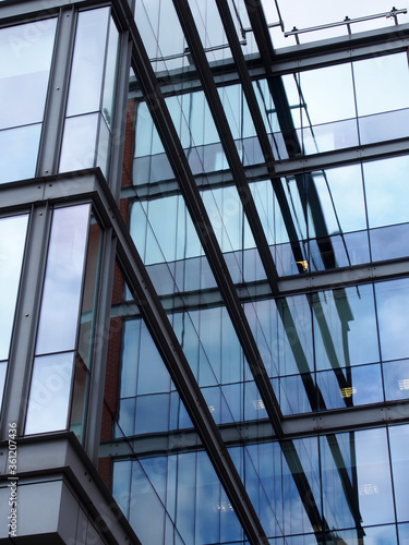 a full frame modern office architecture abstract with geometric shapes and buildings and sky reflected in blue glass windows