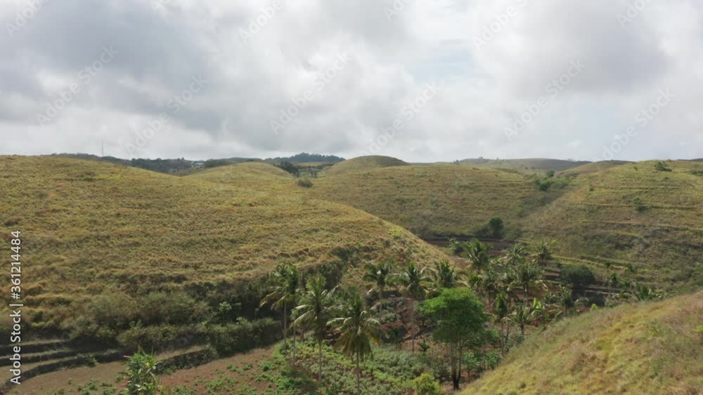 Panoramic Aerial Shot of Teletubbies Hills in Bali, Indonesia with Cloudy Skies Panoramic Aerial Shot of Teletubbies Hills in Bali, Indonesia with Cloudy Skies