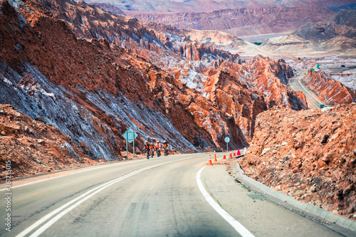 Road leading to San Pedro de Atacama with beautiful red coloured rocks and white coloured salt layer on the side #5