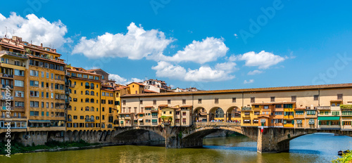 A shot of Ponte Vecchio on the Arno river in Florence Italy with white clouds in the sky