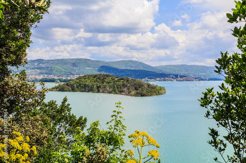 Tree framed view of Isola Minore in Umbria, Italy