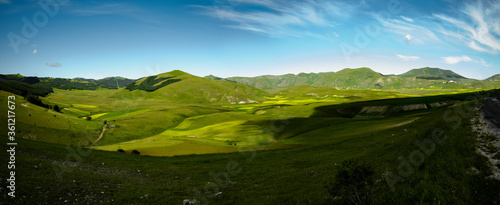 The beginning of flowering around Castelluccio di Norcia (June 2020): fields in lavish color, with red poppies, yellow rapeseed and other flowers.