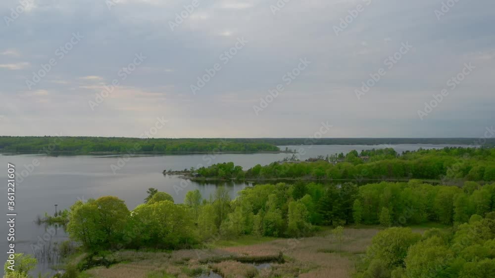 Aerial shot of serene forested island homes on the shores of a great lake Aerial shot of serene forested island homes on the shores of a great lake