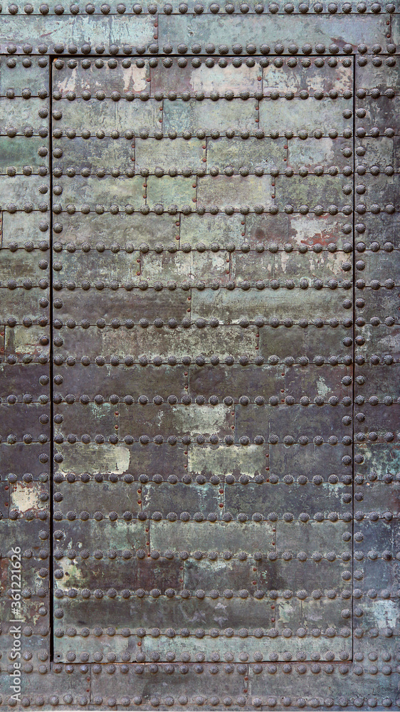 Dirty and rusty metallic door of an abandoned dungeon - irregular iron surface texture with a steampunk aesthetic background Dirty and rusty metallic door of an abandoned dungeon - irregular iron surface texture with a steampunk aesthetic background