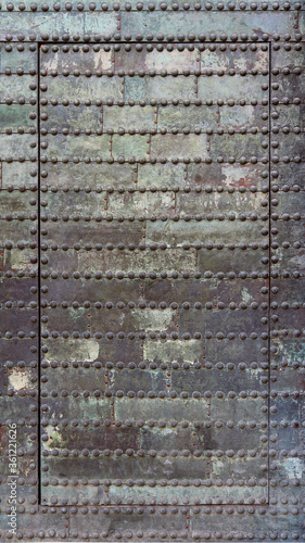 Dirty and rusty metallic door of an abandoned dungeon - irregular iron surface texture with a steampunk aesthetic background