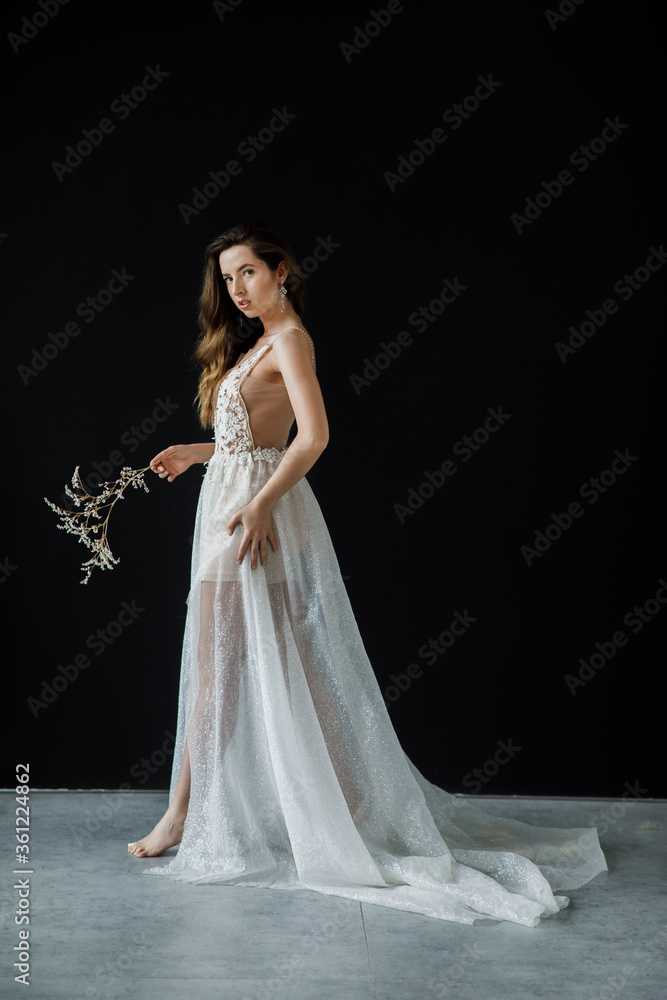 Portrait of a bride in a wedding dress holding a bridal bouquet in hands