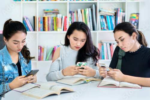 Group of lazy teenage girls studying in the library © Creativa Images