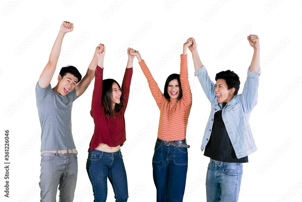 Young people lifting hands together on studio Young people lifting hands together on studio