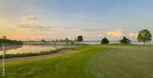 sunrise on golf course hazy sun fog on pond