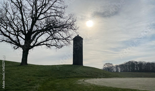 old stone silo on golf course early morning fog hazy sun