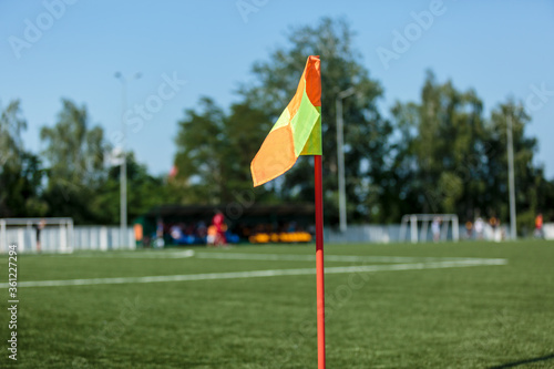 Orange flag on the corner place on the football field over blurred empty stadium. Soccer background