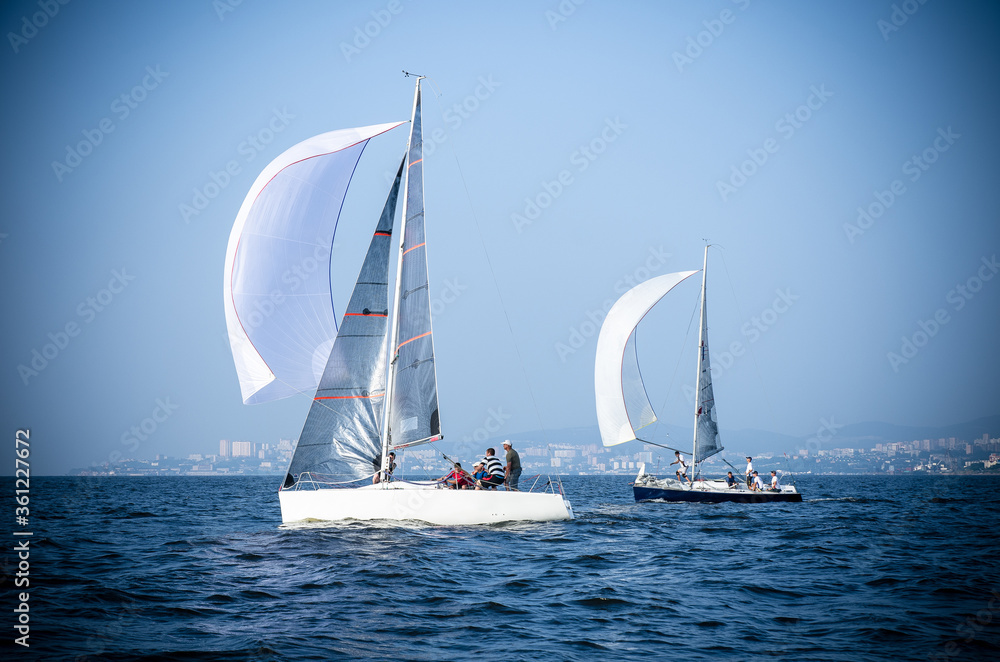 Sailing yacht race. Ship yachts with white sails in the open Sea. Luxury boats