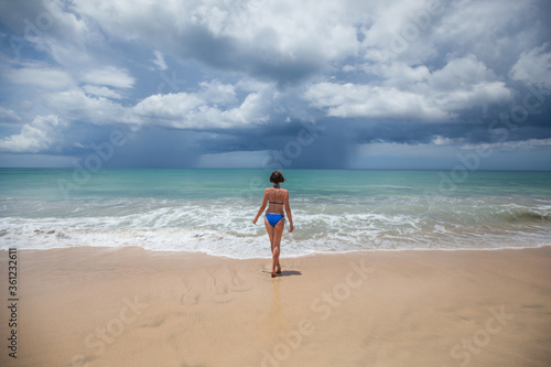 Happy female woman enjoying sunny day on the tropical caribbean sandy beach landscape with turquoise sea and blue sky. Freedom concept 