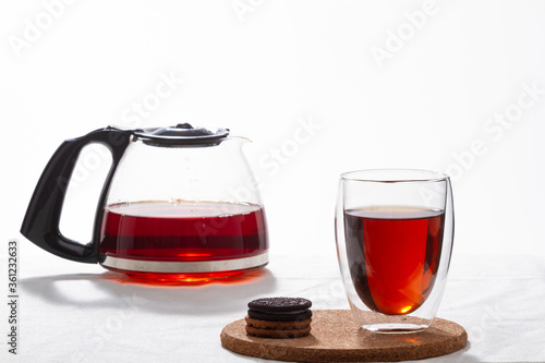 red tea in glass cup and glass teapot