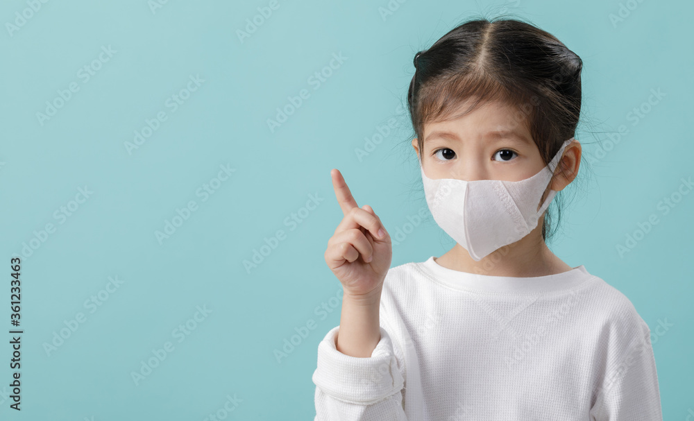 Asian little child girl wearing respirator mask to protect coronavirus outbreak and pointing hand to blank background, New virus Covid-19 from Wuhan China concept, Empty space on blue long banner Asian little child girl wearing respirator mask to protect coronavirus outbreak and pointing hand to blank background, New virus Covid-19 from Wuhan China concept, Empty space on blue long banner