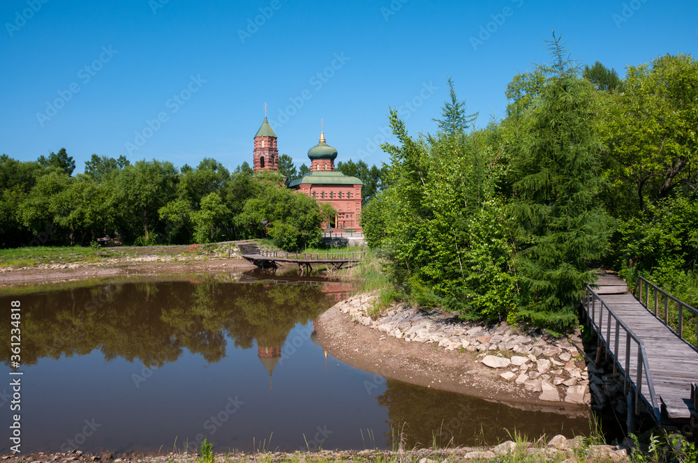 Russian village, summer landscape bridge over the lake and the old Orthodox Church