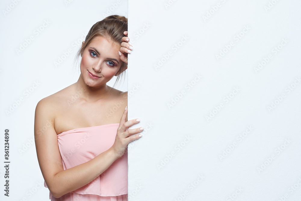 beautiful girl posing in front of the camera. he points to an empty space. advertising concept beautiful girl posing in front of the camera. he points to an empty space. advertising concept