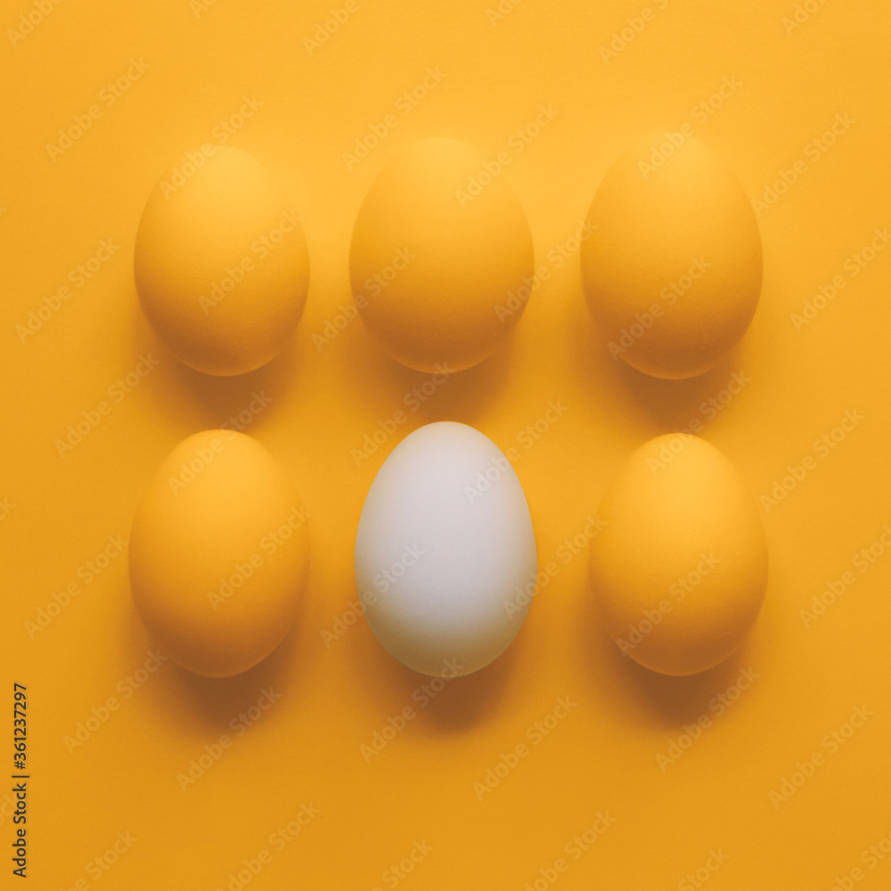 Eggs on yellow background. One white egg and five yellow eggs. Eggs on yellow background. One white egg and five yellow eggs.