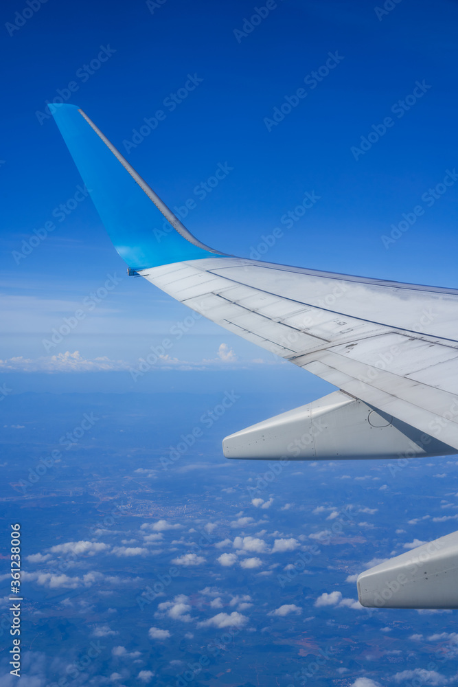 The plane is flying in the sky, the blue sky and white clouds outside the window	
