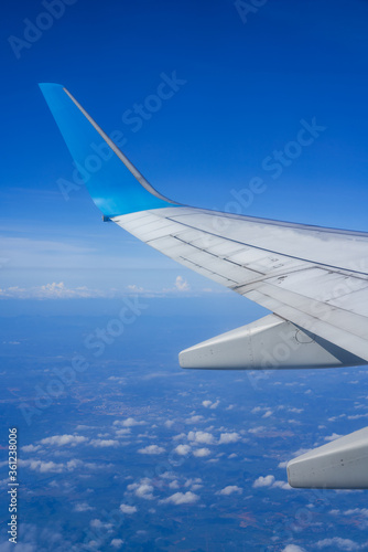 The plane is flying in the sky, the blue sky and white clouds outside the window 