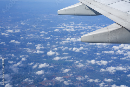The plane is flying in the sky, the blue sky and white clouds outside the window 