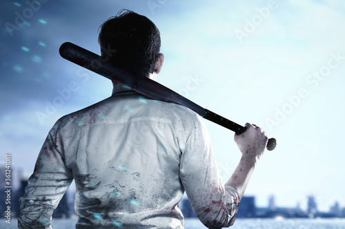 Canvas Print Asian man standing with a baseball bat on his hand on the city