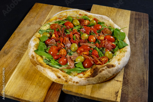 pizza with vegetables on wooden board