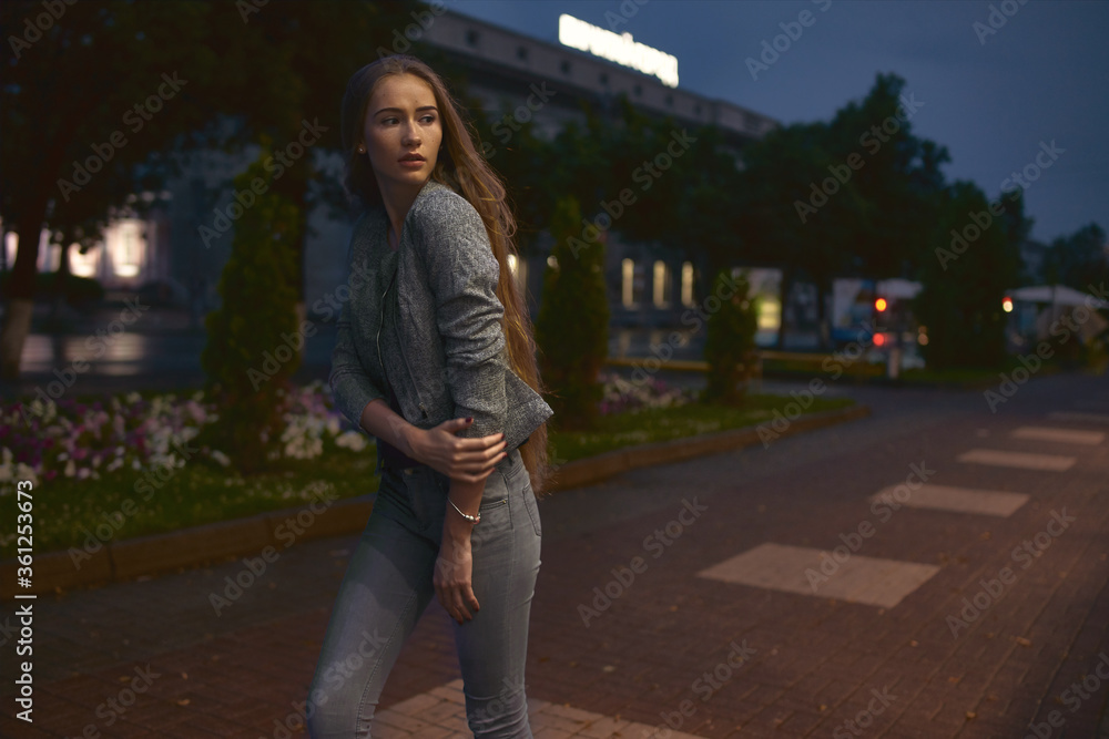 Girl in grey suit posing on the town street