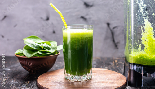 Glass with a vegetarian smoothie from green leaves of fresh spinach. Popular detox drink for healthy eating