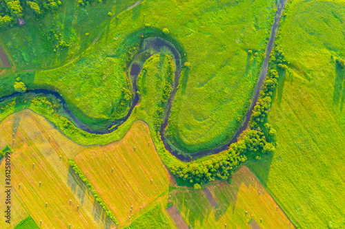 Photo Top aerial view of the natural landscape valley of a meandering river among green fields and forests