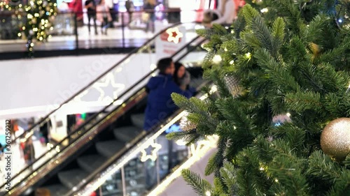 Christmas decorations in Sopping Mall. People on escalator, in festive shopping center, make New Year's purchases,.