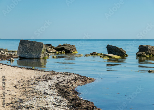 Canvas Print summer landscape with a rocky sea shore, remnants of an old concrete structure i
