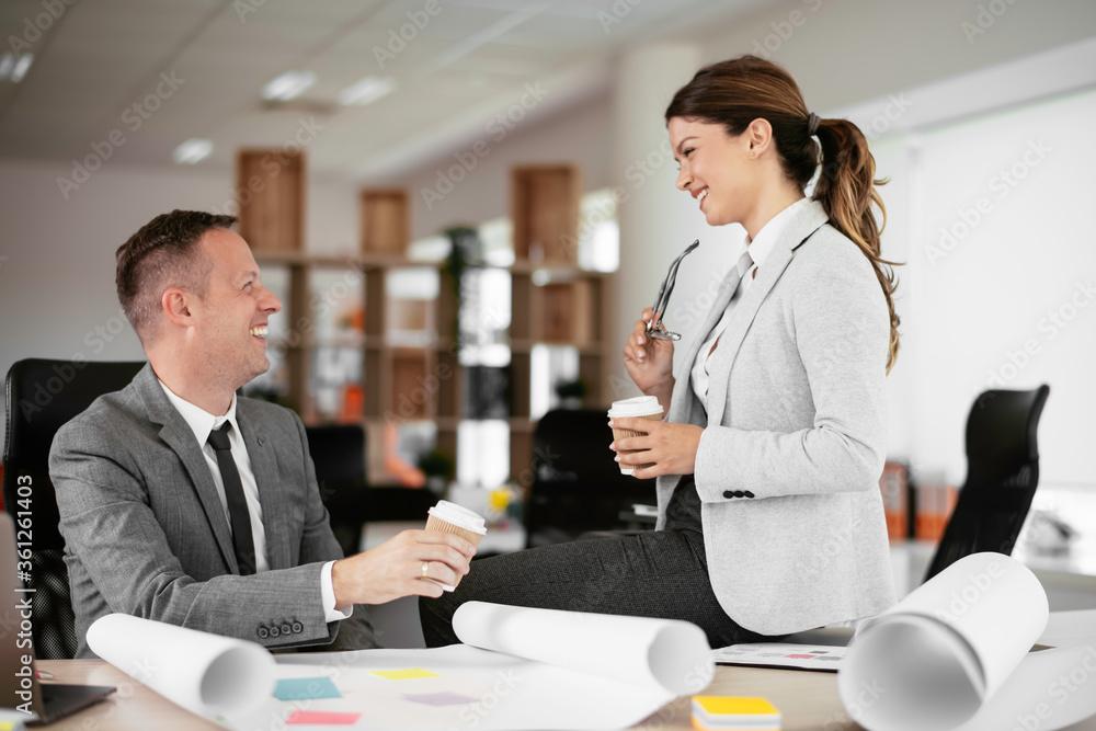 Colleagues in office. Businesswoman and businessman discussing work and drinking coffe in office
Colleagues in office. Businesswoman and businessman discussing work and drinking coffe in office