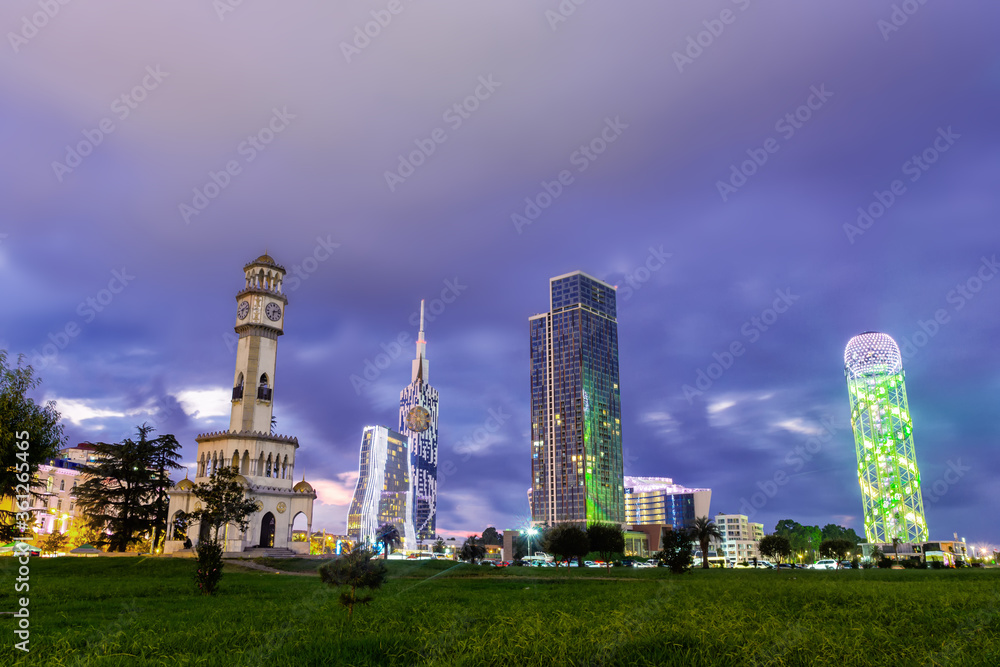 Fototapeta premium Beautiful Batumi, Georgian resort city and port at Black Sea panoramic view of city centre from sea in golden summer morning sunlight