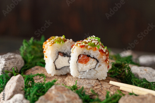 Japanese sushi rolls on a stone stand with moss