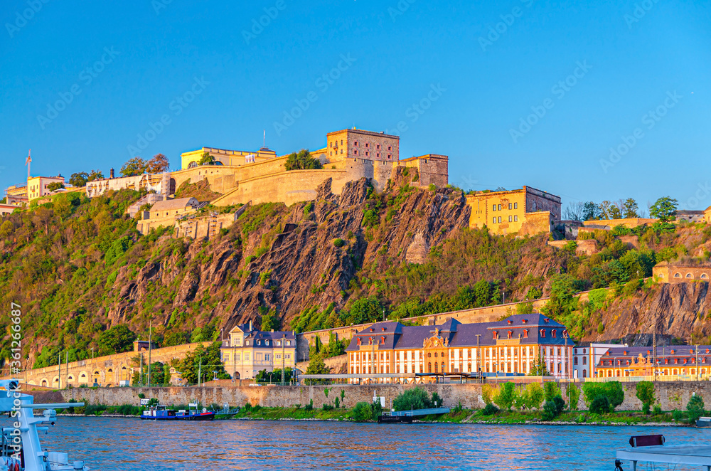 Ehrenbreitstein Fortress medieval building on hill of east steep bank of Rhine river, view from Koblenz city, blue sky background, North Rhine-Westphalia region, Germany